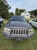 (1) DARK GRAY JEEP GRAND CHEROKEE LAREDO FOUR-DOOR SUV WITH AUTOMATIC TRANSMISSION, 4X4, ROOF RACK, TINTED REAR WINDOWS, ALLOY WHEELS, AND BLACK SEAT COVERS. VEHICLE SHOWS DIRT, CLOUDY HEADLIGHTS, EXTERIOR SCUFFS, MINOR BODY WEAR, AND A MISMATCHED STEEL F - 10