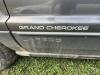 (1) DARK GRAY JEEP GRAND CHEROKEE LAREDO FOUR-DOOR SUV WITH AUTOMATIC TRANSMISSION, 4X4, ROOF RACK, TINTED REAR WINDOWS, ALLOY WHEELS, AND BLACK SEAT COVERS. VEHICLE SHOWS DIRT, CLOUDY HEADLIGHTS, EXTERIOR SCUFFS, MINOR BODY WEAR, AND A MISMATCHED STEEL F - 11