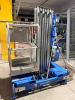GENIE VERTICAL PERSONNEL LIFT WITH TELESCOPING ALUMINUM MAST, ALUMINUM WORK PLATFORM WITH GUARDRAILS, PLATFORM CONTROLS, GROUND CONTROLS, EMERGENCY STOP, OUTRIGGERS, HYDRAULIC LIFT SYSTEM, BATTERY CHARGER, AND MANUAL-ROLLING BASE. - 3