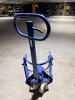 HYDRAULIC DRUM TRANSPORTER WITH MANUAL PUMP HANDLE, CURVED DRUM SUPPORT FRAME, HYDRAULIC GRIPPING ARMS, FLOOR-LEVEL PICKUP DESIGN, STEERABLE REAR WHEELS, AND FRONT LOAD ROLLERS. - 4