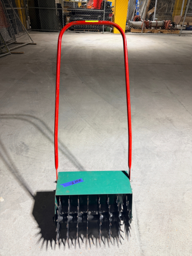 MANUAL PUSH-TYPE SPIKE AERATOR WITH MULTIPLE STEEL STAR-SHAPED SPIKE WHEELS, SPRING-LOADED AXLE ASSEMBLY, STEEL HOUSING, AND LONG TUBULAR PUSH HANDLE.