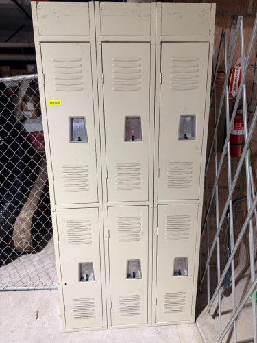 SIX-COMPARTMENT METAL LOCKER ASSEMBLY WITH THREE COLUMNS AND TWO TIERS. BEIGE FINISH WITH LOUVERED STEEL DOORS, RECESSED METAL HANDLE/LOCK ASSEMBLIES, HINGED DOORS, AND CLOSED TOP PANELS