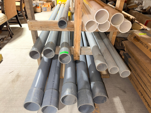 LOT OF ASSORTED RIGID PVC PIPE CONSISTING PRIMARILY OF GRAY AND WHITE STRAIGHT PIPE SECTIONS IN MULTIPLE DIAMETERS. LOT INCLUDES HEAVY-WALL PIPE WITH BELL-END AND STRAIGHT-END CONFIGURATIONS.