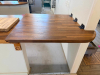 20' CUSTOM SOLID WOOD BUTCHER BLOCK COUNTERTOP SYSTEM WITH MULTIPLE CONNECTED SECTIONS, ROUNDED END SECTIONS, AND WALL-MOUNTED WOOD SUPPORT BRACKETS. COUNTERTOP FEATURES LAMINATED SOLID WOOD CONSTRUCTION WITH STAINED AND SEALED FINISH. INCLUDES MATCHING D - 7