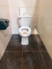 COMMERCIAL RESTROOM FIXTURE PACKAGE INCLUDING DOUBLE-SINK VANITY WITH WHITE SOLID SURFACE TOP, TWO UNDERMOUNT SINK BASINS, TWO BLACK FAUCETS, TWO FRAMED WALL MIRRORS, TWO BLACK WALL-MOUNTED LIGHT FIXTURES, TWO TOILETS, TOILET PARTITIONS, PAPER TOWEL DISPE - 8