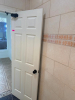 COMMERCIAL RESTROOM FIXTURE PACKAGE INCLUDING DOUBLE-SINK VANITY WITH WHITE SOLID SURFACE TOP, TWO UNDERMOUNT SINK BASINS, TWO BLACK FAUCETS, TWO FRAMED WALL MIRRORS, TWO BLACK WALL-MOUNTED LIGHT FIXTURES, TWO TOILETS, TOILET PARTITIONS, PAPER TOWEL DISPE - 9