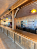 60'X 14' " U " SHAPED CUSTOM-BUILT U-SHAPED COMMERCIAL BAR WITH RUSTIC WOOD CONSTRUCTION, RAISED BAR TOP, LOWER WORK COUNTERS, EXTENSIVE BASE CABINETRY, DRAWERS, STORAGE COMPARTMENTS, DECORATIVE WOOD PANELS, HEAVY TIMBER POSTS, OVERHEAD WOOD BEAM/CANOPY S - 5