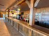60'X 14' " U " SHAPED CUSTOM-BUILT U-SHAPED COMMERCIAL BAR WITH RUSTIC WOOD CONSTRUCTION, RAISED BAR TOP, LOWER WORK COUNTERS, EXTENSIVE BASE CABINETRY, DRAWERS, STORAGE COMPARTMENTS, DECORATIVE WOOD PANELS, HEAVY TIMBER POSTS, OVERHEAD WOOD BEAM/CANOPY S - 6