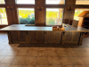 16' X 8'4" CUSTOM-BUILT COMMERCIAL SERVICE COUNTER WITH SOLID WOOD CABINETRY, RAISED PANEL DOORS, MULTIPLE DRAWERS, OPEN STORAGE SECTIONS, DECORATIVE TRIM, HEAVY WOOD BASE AND DARK TEXTURED COUNTERTOP WITH WOOD EDGE TRIM. COUNTER IS CONFIGURED IN A LARGE - 2