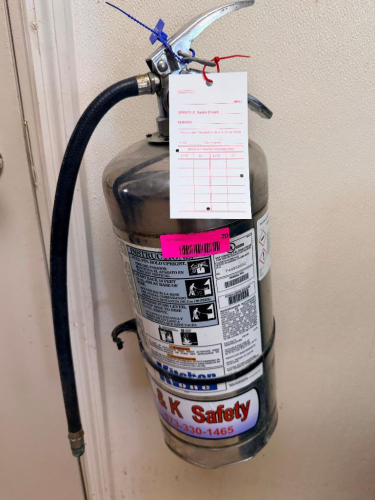 WET CHEMICAL FIRE EXTINGUISHER W/ WALL MOUNTED HOOK.