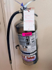 WET CHEMICAL FIRE EXTINGUISHER W/ WALL MOUNTED HOOK.