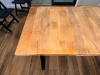72" X 36" SOLID WOOD DINING / COMMUNITY TABLE WITH WIDE PLANK TOP AND BLACK METAL TRESTLE-STYLE LEGS. NATURAL WOOD TOP FEATURES VISIBLE GRAIN, KNOTS, COLOR VARIATION, AND A LIGHTLY DISTRESSED/RUSTIC FINISH. - 3