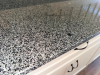 130" SPECKLED GRANITE COUNTERTOP AND MATCHING GRANITE BACKSPLASH. WHITE SHAKER-STYLE CABINETRY INCLUDES MULTIPLE DRAWERS, DOUBLE-DOOR STORAGE COMPARTMENTS, ADJUSTABLE/REMOVABLE INTERIOR SHELVING, AND DARK METAL PULL HARDWARE - 3