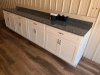 130" SPECKLED GRANITE COUNTERTOP AND MATCHING GRANITE BACKSPLASH. WHITE SHAKER-STYLE CABINETRY INCLUDES MULTIPLE DRAWERS, DOUBLE-DOOR STORAGE COMPARTMENTS, ADJUSTABLE/REMOVABLE INTERIOR SHELVING, AND DARK METAL PULL HARDWARE - 5