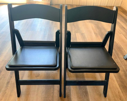 (12) BLACK WOOD FOLDING CHAIRS WITH PADDED BLACK VINYL SEATS AND CURVED SOLID BACKRESTS.