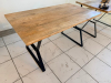 55" X 32" SOLID WOOD DINING / COMMUNITY TABLE WITH WIDE PLANK TOP AND BLACK METAL TRESTLE-STYLE LEGS. NATURAL WOOD TOP FEATURES VISIBLE GRAIN, KNOTS, COLOR VARIATION, AND A LIGHTLY DISTRESSED/RUSTIC FINISH. - 2