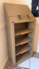 FREESTANDING WOOD DISPLAY SHELVING UNIT WITH SLOPED UPPER SIGN/DISPLAY PANEL, THREE OPEN SHELVES, LOWER BASE SHELF, AND TWO METAL BRACKETS MOUNTED TO THE UPPER PANEL. PAINTED GRAY FINISH