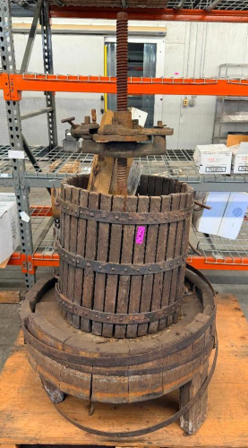 ANTIQUE WOODEN BASKET WINE / FRUIT PRESS WITH VERTICAL WOOD SLAT PRESSING BASKET, HEAVY STEEL BANDS, CAST IRON PRESSING MECHANISM, LARGE THREADED SCREW, WOOD PRESS BLOCKS, AND WOODEN COLLECTION BASE. UNIT SHOWS HEAVY AGE, WEATHERING, SURFACE RUST, WOOD DE