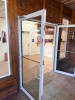 PAIR OF COMMERCIAL FULL-VIEW ALUMINUM-FRAMED GLASS ENTRY DOORS WITH CLEAR TEMPERED GLASS PANELS, PULL HANDLES, HORIZONTAL PUSH BARS, OVERHEAD HYDRAULIC DOOR CLOSERS, HINGE HARDWARE, AND ASSOCIATED FRAME COMPONENTS. WHITE FINISH. - 2