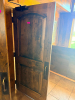 SOLID CORE WOOD DOOR WITH STAINED FINISH, ARCHED RAISED PANEL DESIGN, HEAVY-DUTY HINGES, METAL PULL HANDLE, AND OVERHEAD HYDRAULIC DOOR CLOSER.