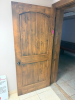 SOLID CORE WOOD DOOR WITH STAINED FINISH, ARCHED RAISED PANEL DESIGN, HEAVY-DUTY HINGES, METAL PULL HANDLE, AND OVERHEAD HYDRAULIC DOOR CLOSER.