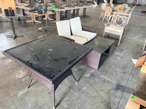 36" X 26" WICKER PATIO TABLE W/ GLASS TOP, LOVE SEAT WITH WHITE CUSHIONS, COFFEE TABLE, AND WOODEN ARM CHAIR.
