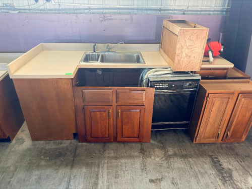 WOOD BASE CABINET AND COUNTERTOP ASSEMBLY WITH RAISED-PANEL CABINET DOORS, LIGHT-COLORED LAMINATE COUNTERTOP WITH BACKSPLASH, STAINLESS STEEL DOUBLE-BOWL SINK, FAUCET, AND SIDE SPRAYER. CABINET DOORS ARE DETACHED AS SHOWN.
