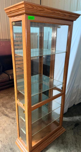 TALL OAK-FINISH GLASS DISPLAY CABINET WITH GLASS FRONT AND SIDE PANELS, MIRRORED INTERIOR BACK, GLASS SHELVES, AND DECORATIVE CROWN AND BASE MOLDING.