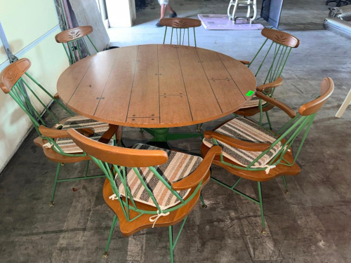 7-PIECE ROUND DINING SET CONSISTING OF (1) ROUND WOOD-TOP DINING TABLE AND (6) MATCHING ARMCHAIRS. TABLE FEATURES A PLANK-STYLE WOOD TOP WITH DECORATIVE DARK ACCENT LINES AND GREEN PAINTED PEDESTAL BASE. CHAIRS FEATURE GREEN METAL FRAMES, WOOD ARMRESTS AN