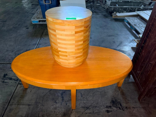 OVAL WOOD COFFEE TABLE WITH WARM HONEY-TONE FINISH, SOLID TOP, APRON, AND FOUR STRAIGHT LEGS. INCLUDES MATCHING CYLINDRICAL BLOCK-WOOD ACCENT/STOOL