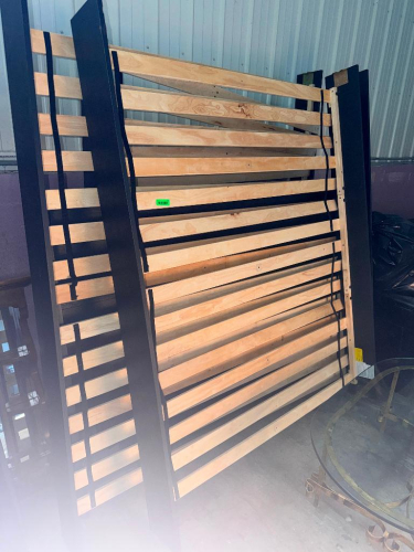 WOOD PLATFORM BED FRAME WITH DARK FINISHED SIDE RAILS, HEADBOARD/FOOTBOARD COMPONENTS, AND NATURAL WOOD MATTRESS SUPPORT SLATS.