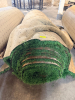 7.5' W X 40' L ARTIFICIAL TURF / ASTROTURF WITH GREEN SYNTHETIC GRASS SURFACE AND WOVEN BACKING. TURF IS ROLLED FOR STORAGE AND SHOWS VISIBLE DIRT, WEAR, FRAYING, AND RESIDUE CONSISTENT WITH PREVIOUS INSTALLATION AND REMOVAL.
