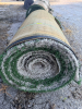 7.5' W X 40' L ARTIFICIAL TURF / ASTROTURF WITH GREEN SYNTHETIC GRASS SURFACE AND WOVEN BACKING. TURF IS ROLLED FOR STORAGE AND SHOWS VISIBLE DIRT, WEAR, FRAYING, AND RESIDUE CONSISTENT WITH PREVIOUS INSTALLATION AND REMOVAL.
