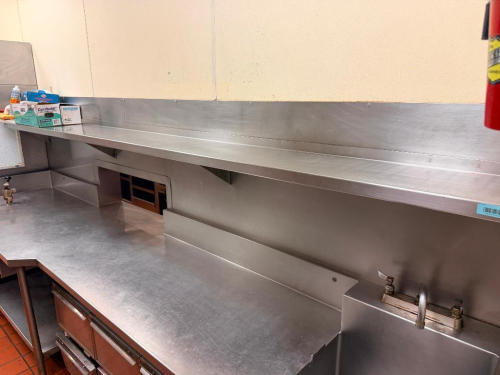 138" L X APPROX. 12" STAINLESS STEEL WALL-MOUNT OVER SHELF WITH INTEGRAL BACKSPLASH, RAISED REAR AND SIDE EDGES, AND WALL SUPPORT BRACKETS. HEAVY-GAUGE STAINLESS STEEL CONSTRUCTION.