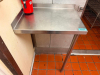 STAINLESS STEEL WALL-MOUNT WORK TABLE WITH GALVANIZED TUBULAR SUPPORT LEG AND INTEGRAL BACKSPLASH. HEAVY-GAUGE STAINLESS STEEL WORK SURFACE WITH RAISED FRONT EDGE.