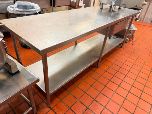 95" L X 30" W STAINLESS STEEL WORK TABLE WITH FULL-LENGTH UNDERSHELF, TWO INTEGRATED DRAWERS, TUBULAR LEGS, AND REINFORCED STAINLESS STEEL WORK SURFACE.