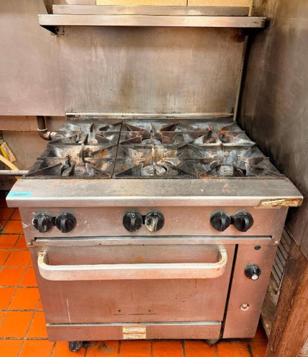 VULCAN COMMERCIAL SIX-BURNER NATURAL GAS RANGE WITH STANDARD OVEN BASE, HEAVY-DUTY CAST IRON OPEN-TOP GRATES, INDIVIDUAL BURNER CONTROLS, STAINLESS STEEL FRONT, BACKSPLASH, OVEN RACK, AND CASTERS.