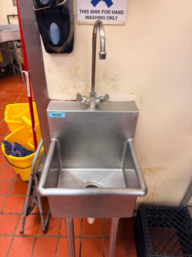 COMMERCIAL STAINLESS STEEL SINGLE-COMPARTMENT HAND WASH SINK WITH INTEGRAL BACKSPLASH, DEEP SINK BASIN, ROUNDED FRONT AND SIDE EDGES, TALL GOOSENECK FAUCET WITH HOT AND COLD CONTROLS, DRAIN AND FOUR-LEG SUPPORT BASE.
