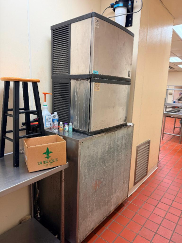 MANITOWOC SELF-CONTAINED ICE MAKER WITH STAINLESS STEEL EXTERIOR, DUAL-SECTION ICE MAKER HEAD, LOUVERED CONDENSER PANELS, AND LARGE ICE STORAGE BIN.