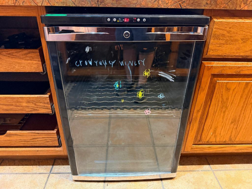 AVANTI SINGLE-DOOR WINE REFRIGERATOR WITH BLACK CABINET, GLASS DOOR, CHROME-TONE HANDLE, DIGITAL TEMPERATURE CONTROL, LOCKING DOOR, AND WIRE WINE BOTTLE RACK.