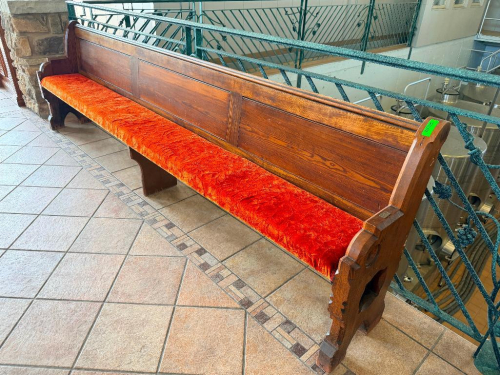 128" ANTIQUE EXTRA-LONG SOLID WOOD BENCH WITH HIGH PANELED BACK, DECORATIVE CARVED END SUPPORTS, AND RED UPHOLSTERED SEAT. HEAVY WOOD CONSTRUCTION WITH DARK STAINED FINISH