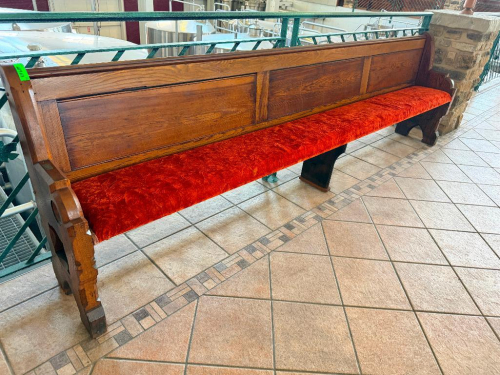 128" ANTIQUE EXTRA-LONG SOLID WOOD BENCH WITH HIGH PANELED BACK, DECORATIVE CARVED END SUPPORTS, AND RED UPHOLSTERED SEAT. HEAVY WOOD CONSTRUCTION WITH DARK STAINED FINISH