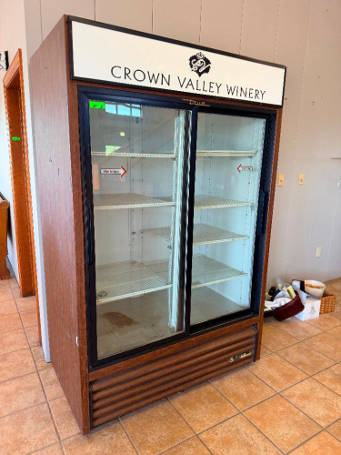 TRUE TWO-SECTION SLIDING GLASS DOOR REFRIGERATED MERCHANDISER WITH INTERIOR WIRE SHELVING, BOTTOM-MOUNT REFRIGERATION SYSTEM, WOOD-GRAIN EXTERIOR FINISH, AND CROWN VALLEY WINERY BRANDED HEADER.