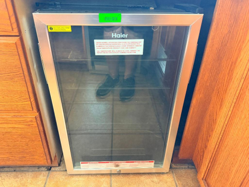 NEWAIR FREESTANDING WINE COOLER WITH GLASS FRONT DOOR, STAINLESS-FINISH DOOR FRAME, INTERIOR WINE RACKS, AND TEMPERATURE CONTROL.