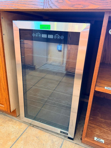 NEWAIR FREESTANDING WINE COOLER WITH GLASS FRONT DOOR, STAINLESS-FINISH DOOR FRAME, INTERIOR WINE RACKS, AND TEMPERATURE CONTROL.
