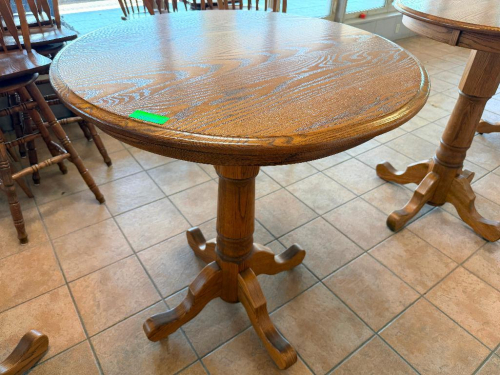 36" ROUND OAK PEDESTAL TABLE WITH WOOD-GRAIN FINISH, MOLDED EDGE, SINGLE TURNED CENTER PEDESTAL, AND FOUR-FOOT BASE.