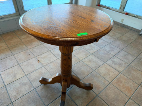 30" ROUND OAK PEDESTAL TABLE WITH WOOD-GRAIN FINISH, MOLDED EDGE, SINGLE TURNED CENTER PEDESTAL, AND FOUR-FOOT BASE.