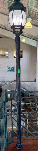 DECORATIVE FREESTANDING LAMP POST WITH BLACK FLUTED COLUMN, ORNATE LANTERN-STYLE FIXTURE, CLEAR TEXTURED GLASS PANELS, AND MULTIPLE CANDELABRA-STYLE LIGHTS.