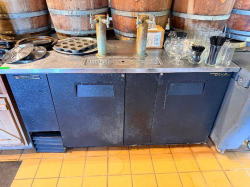 TRUE 3-DOOR UNDERCOUNTER REFRIGERATOR WITH STAINLESS STEEL TOP, BLACK EXTERIOR, AND (2) DRAFT BEER TOWERS WITH DUAL FAUCETS. INCLUDES BUILT-IN DRAINBOARD.