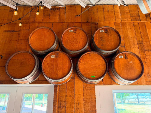 (7) WOOD WINE BARRELS MOUNTED HORIZONTALLY TO WALL, WITH WOOD STAVE CONSTRUCTION AND METAL HOOPS.